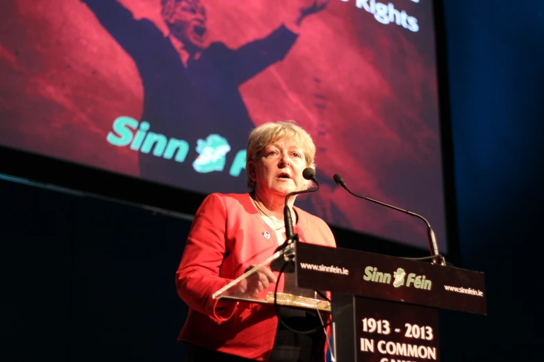 a woman standing at a podium with a microphone