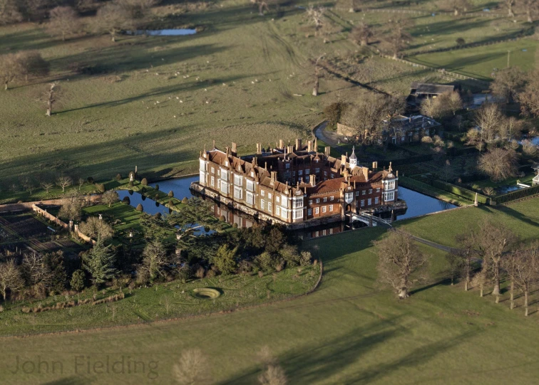 an aerial po of an enormous house in the countryside