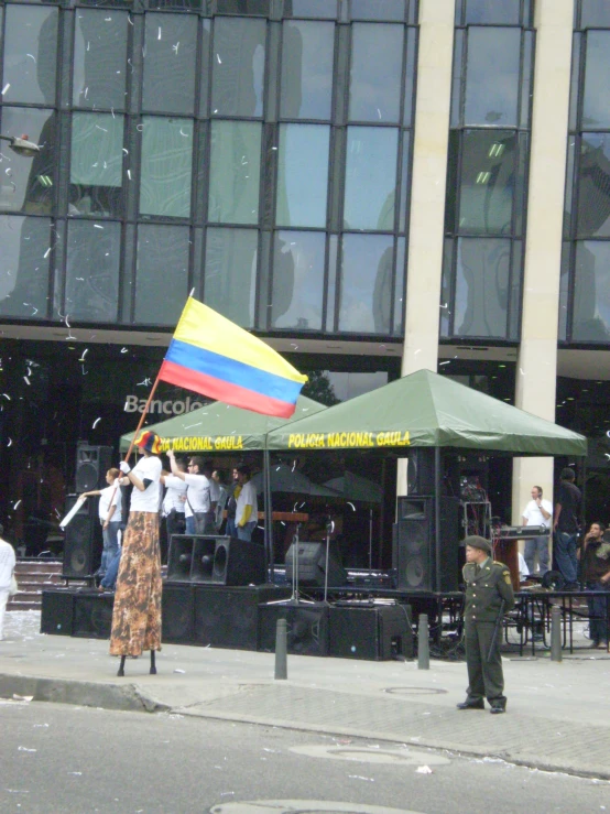 a woman walks by a large colored umbrella