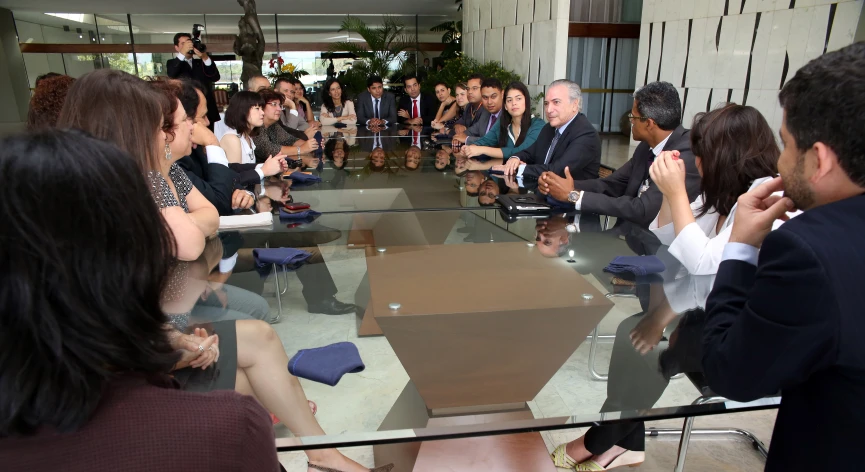 a group of people sitting around a glass table