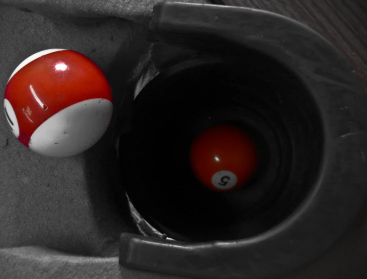 two pool balls in a grey box with an eight - ball