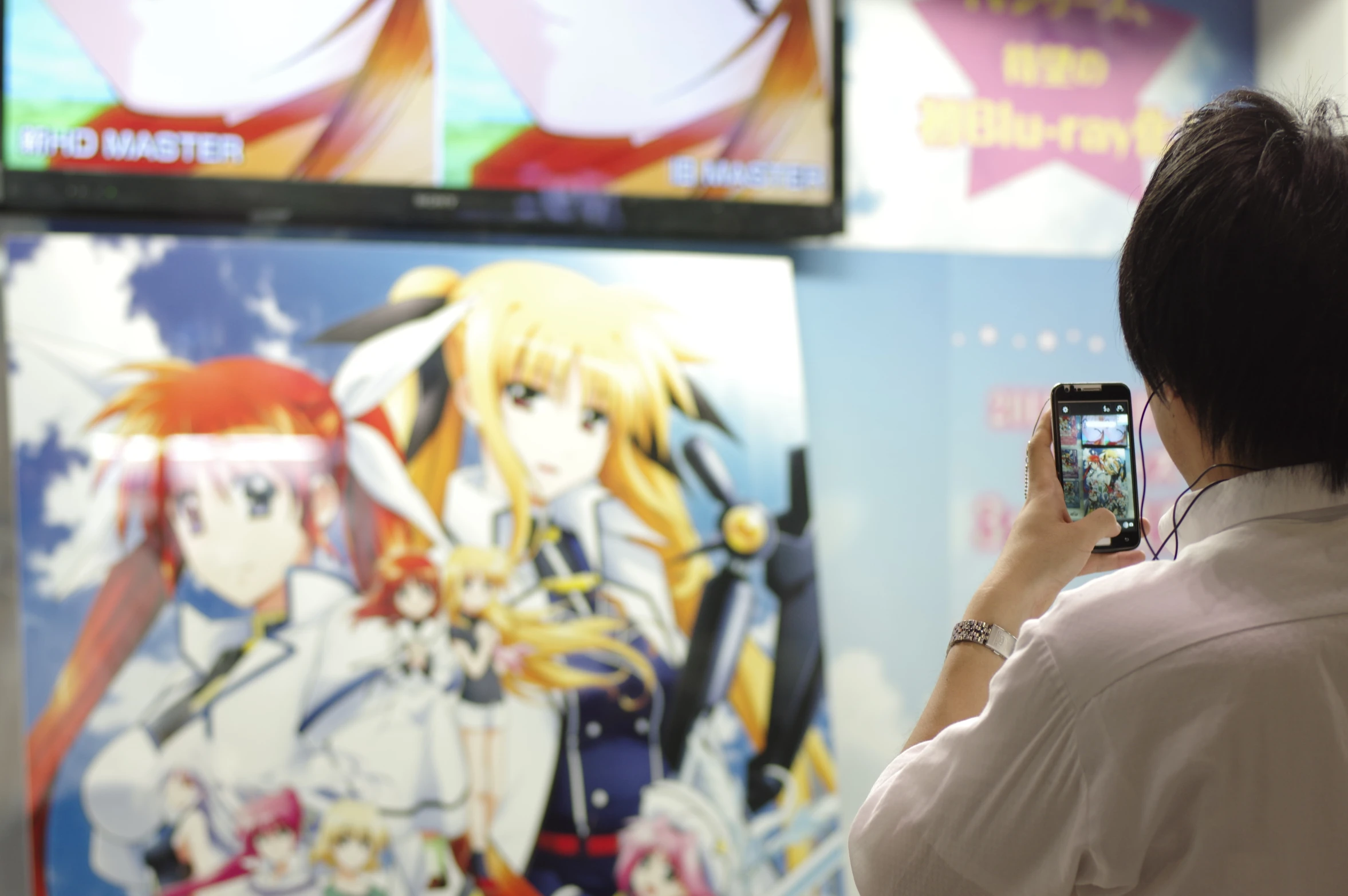 a woman taking a po of an anime wallpaper