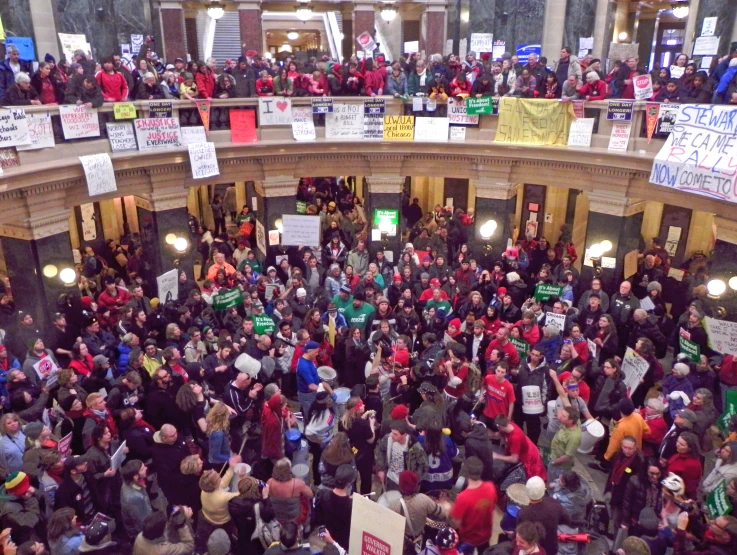 a crowd in a building with banners and other signs on the wall