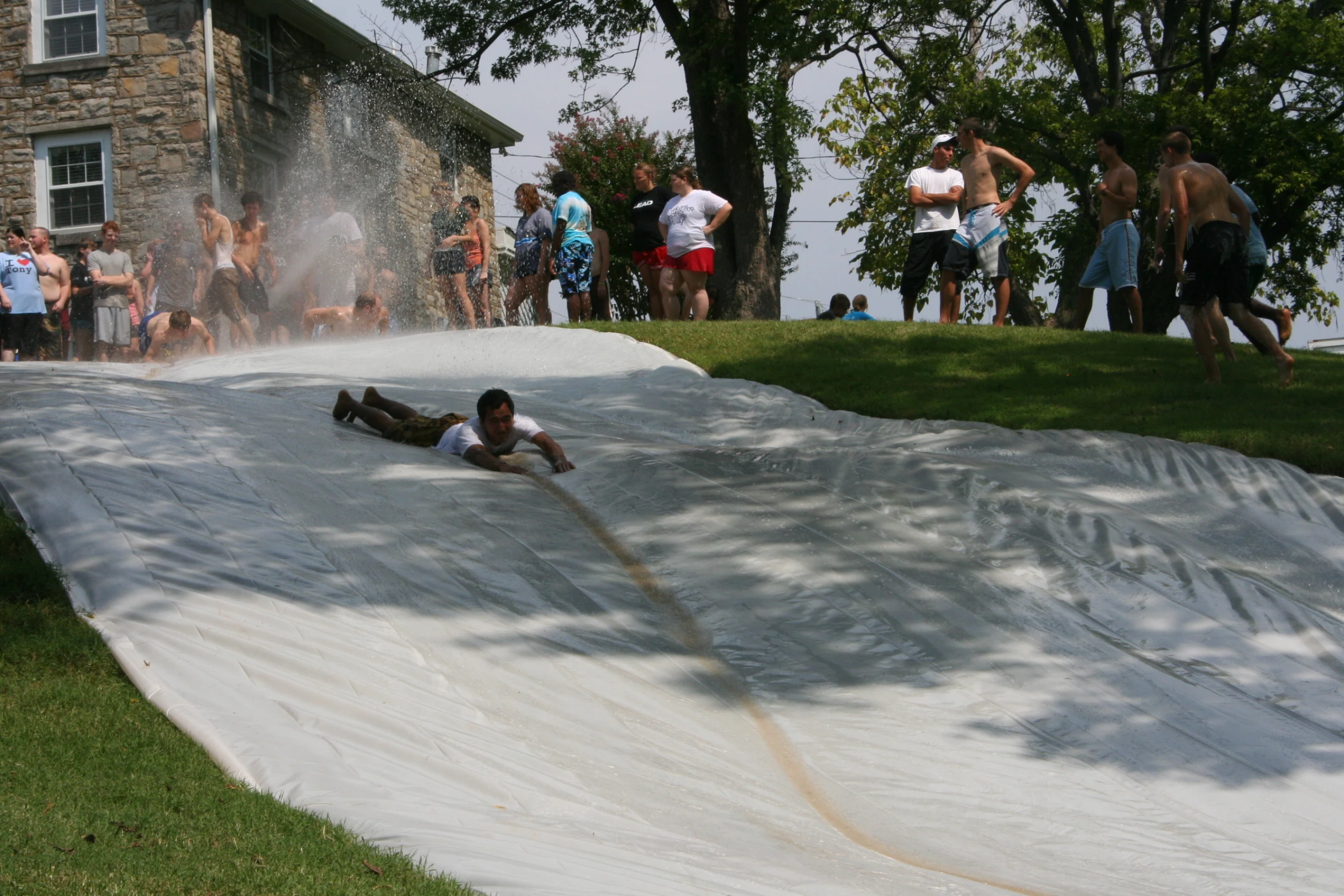 some people watching a man sliding down a hill