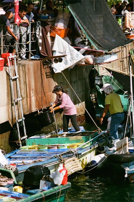 several boats parked on a small river near a wall