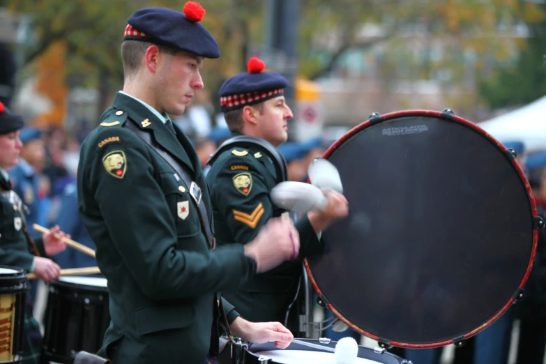 two military men playing drums near an audience