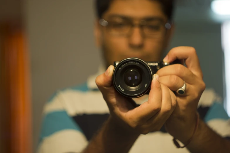 someone with glasses holding up a camera