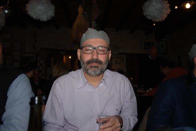 a man at a restaurant with glasses in his hand