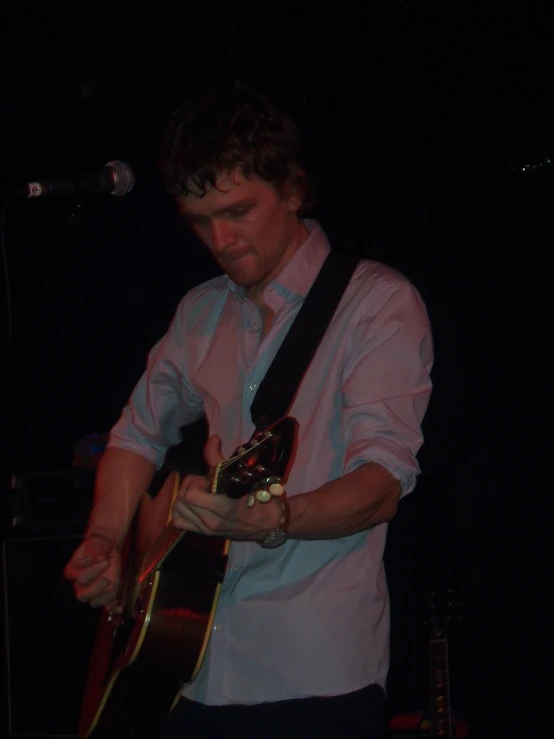 a person playing guitar in a dimly lit room