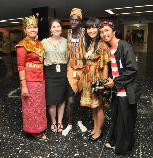 several women and men dressed up standing outside of an airport