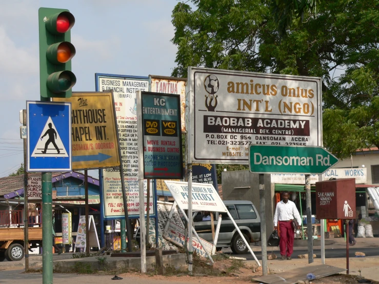 various signs are posted on poles in the middle of the street