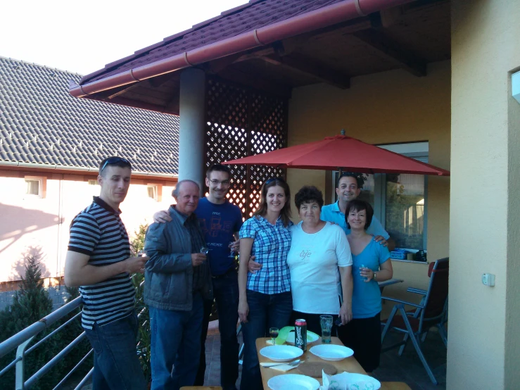 five people standing around outside an outdoor restaurant