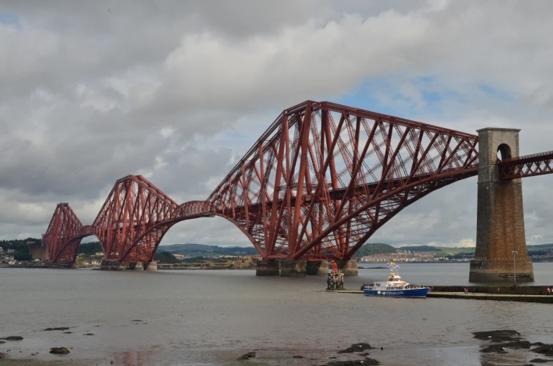 a red bridge spanning the width of a body of water