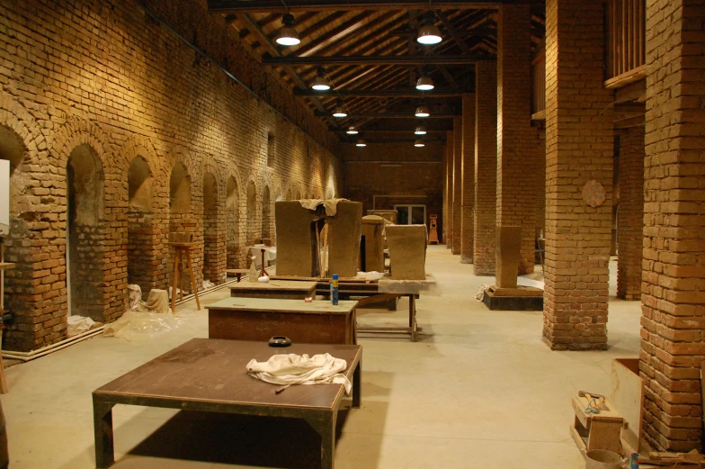 rows of benches and tables in an old, stone - bricked building