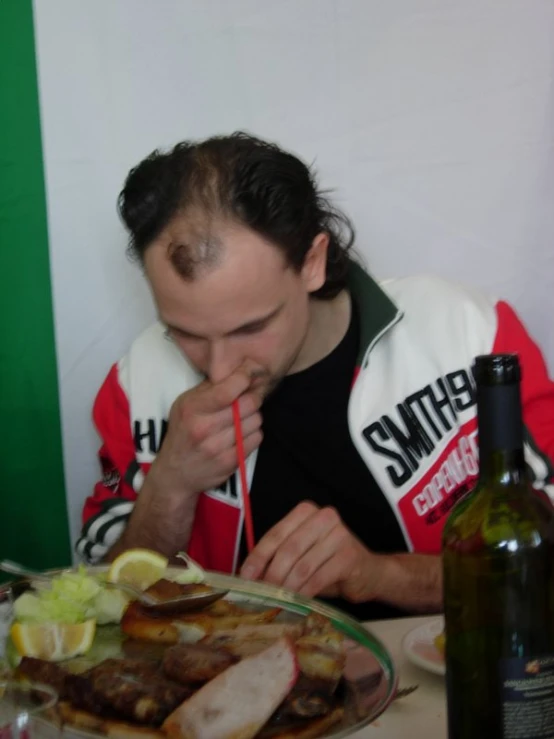 a man sitting at a table with a plate of food