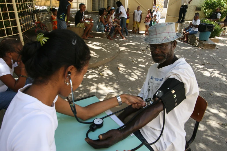 a woman sitting at a table with a doctor and stethoscope