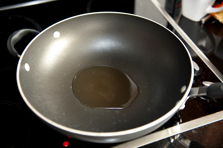 a silver frying pan with a brown spot inside