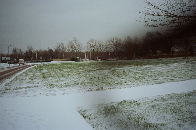 a large open field covered with snow during a winter storm