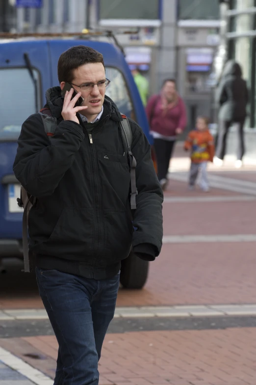 a man walking down the street on his cell phone