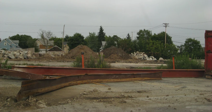 an old rusted rail in an open lot next to a row of buildings