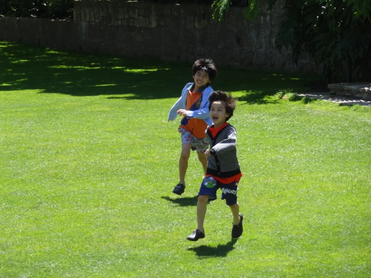 two s in the park playing with an orange frisbee