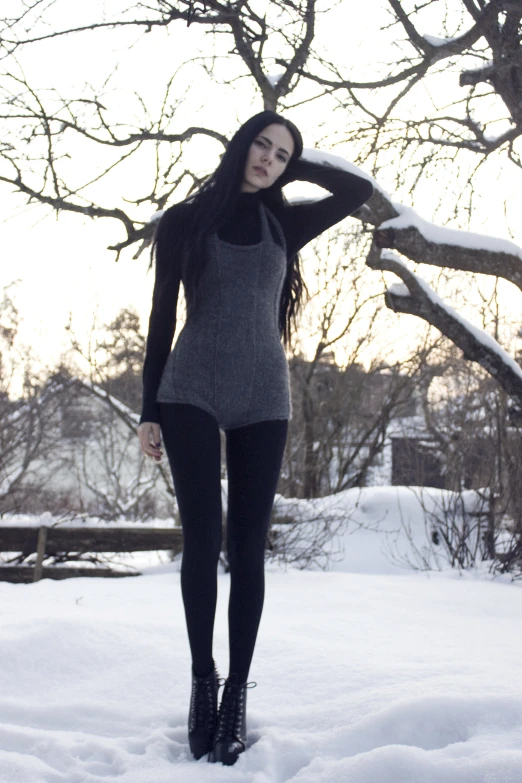 a beautiful woman in tight pants standing outside in the snow