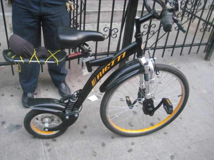 a man is standing with a bike next to a fence