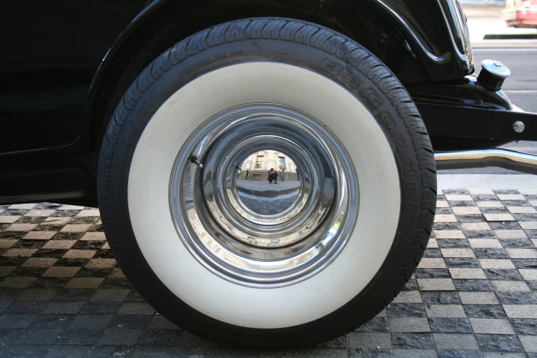 the tire of an antique car on a street