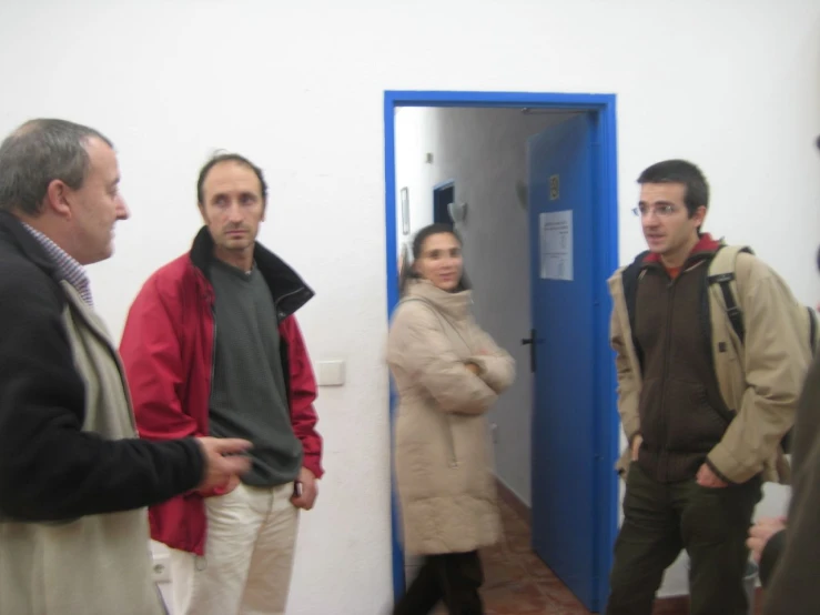 three people standing in front of a door