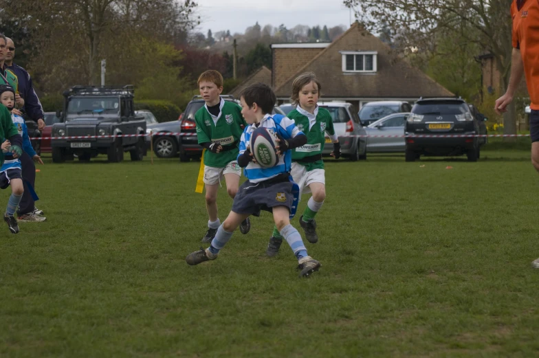 a boy tries to get his soccer ball while his teammates watch