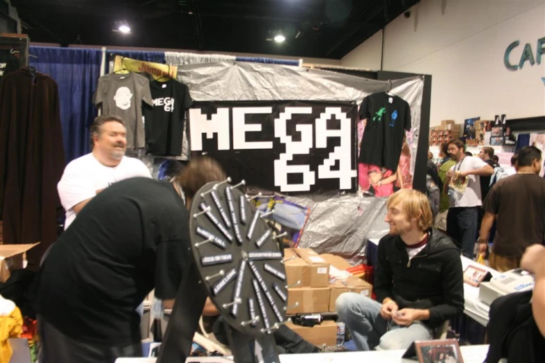 people standing around some fans and boxes in a convention
