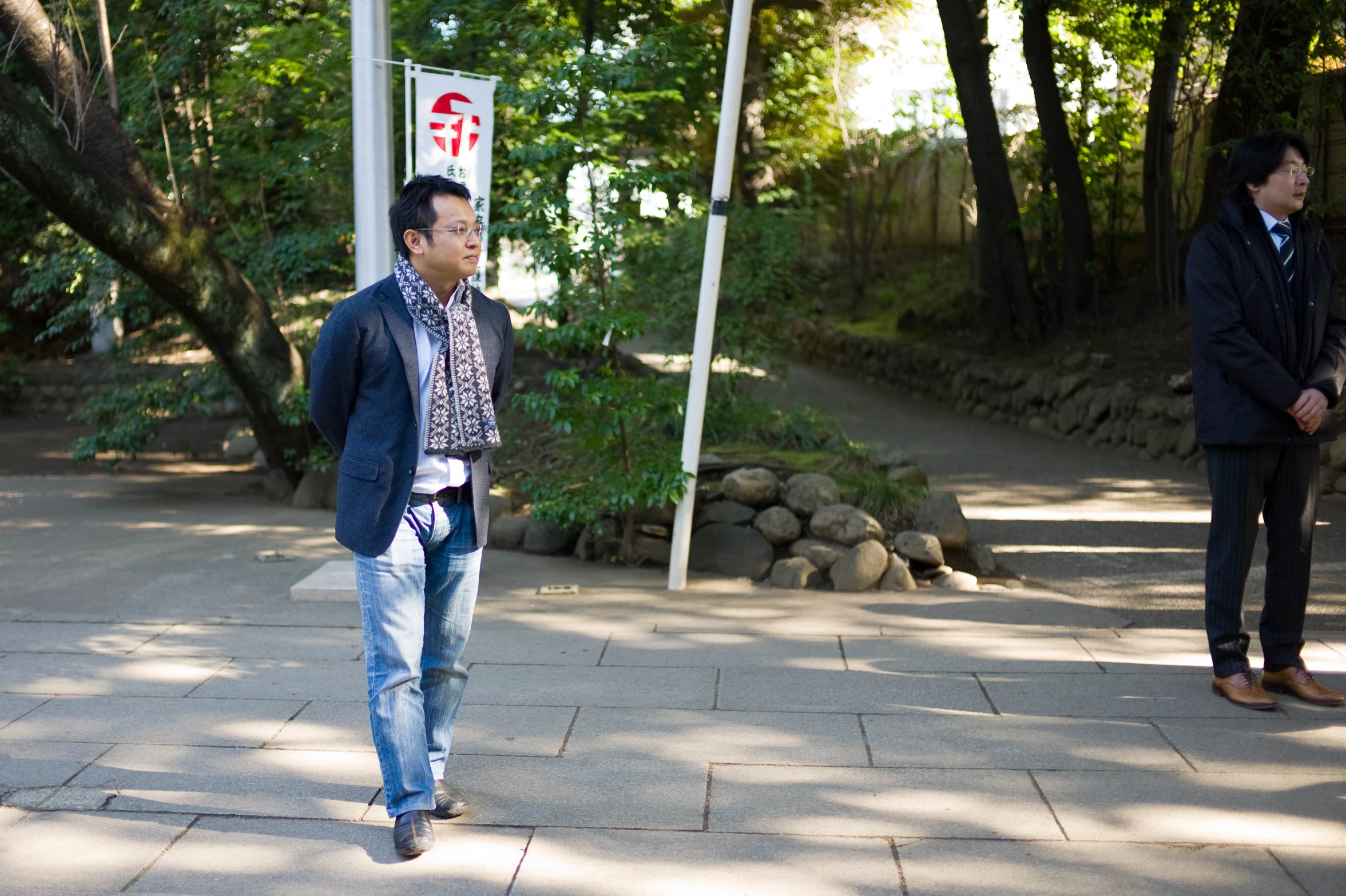 an asian man wearing blue jeans and a blazer