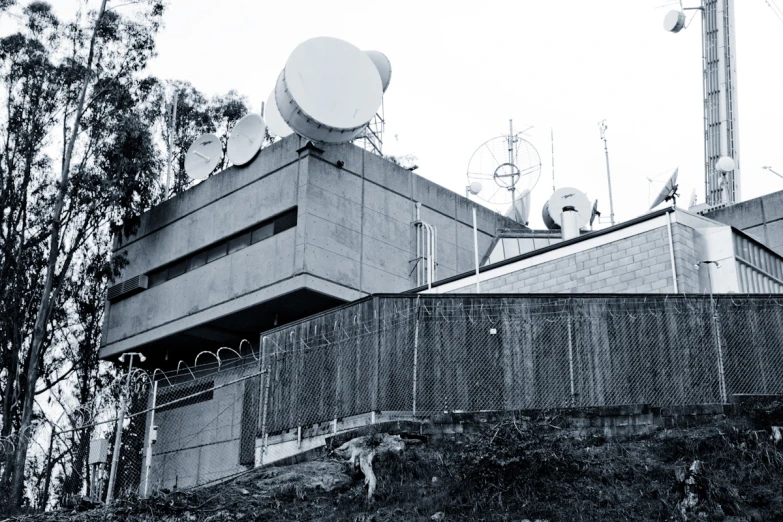 a satellite dish on top of a building near some trees