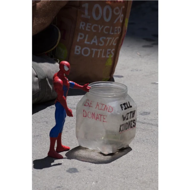 toy spider - man figure in front of plastic glass jar with saying