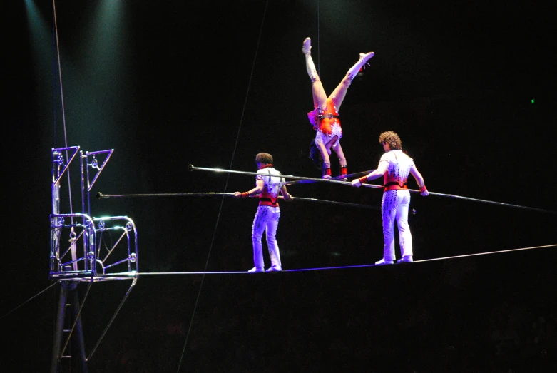 four people performing a stunt while two adults watch from below