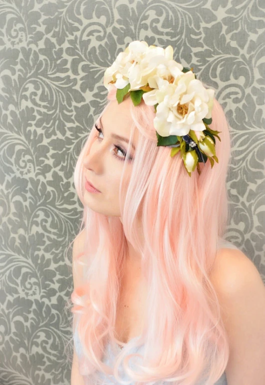 a woman with long pink hair has flowers in her hair
