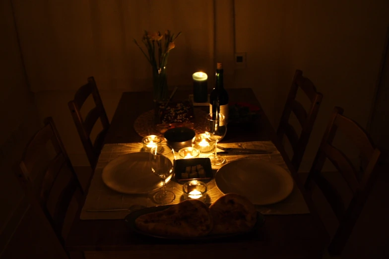 a dinner table with lit candles around the table