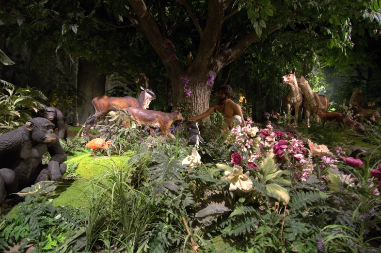 animals are surrounded by flowers and greenery in an exhibit