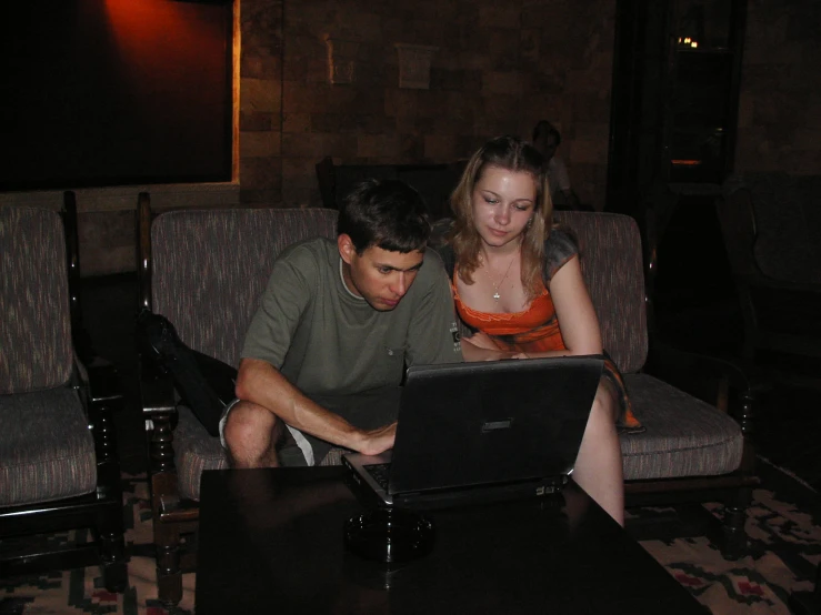 two people look at soing on a laptop computer