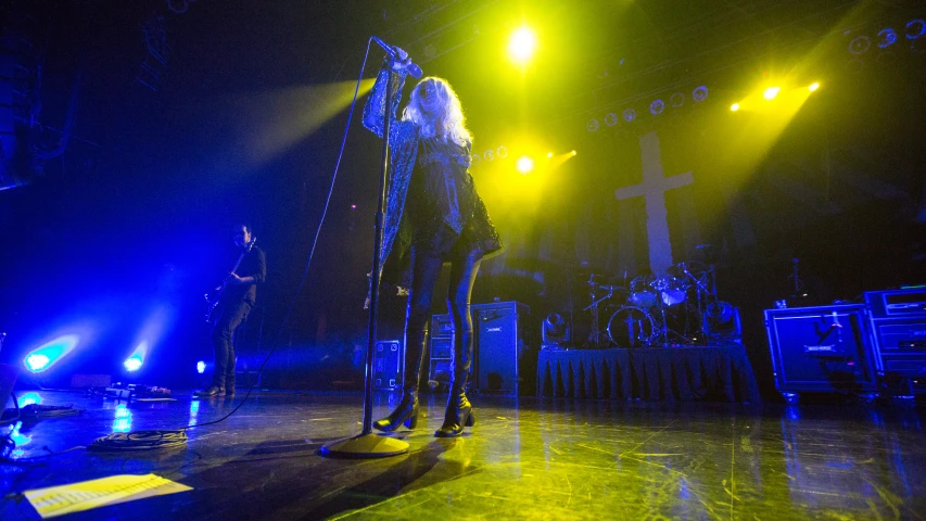 two women are on stage with microphones and lights