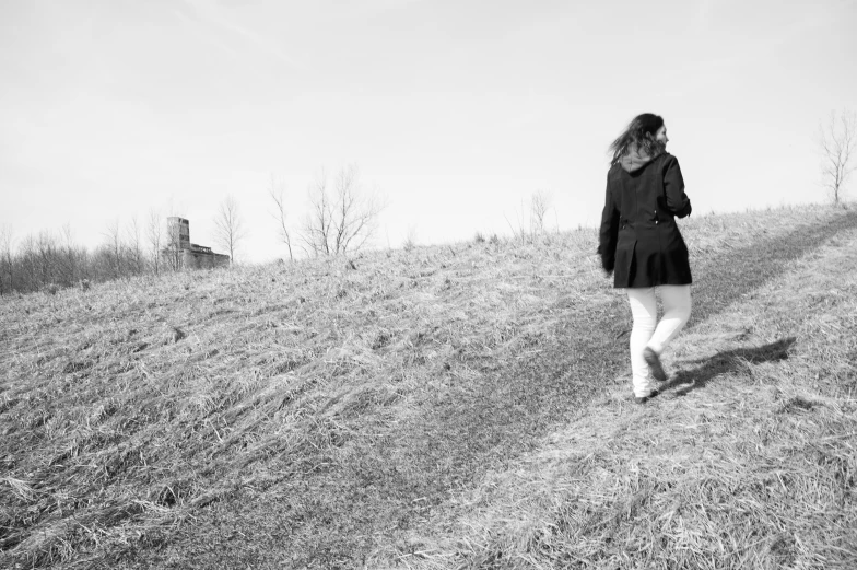 black and white po of a woman walking up a hill