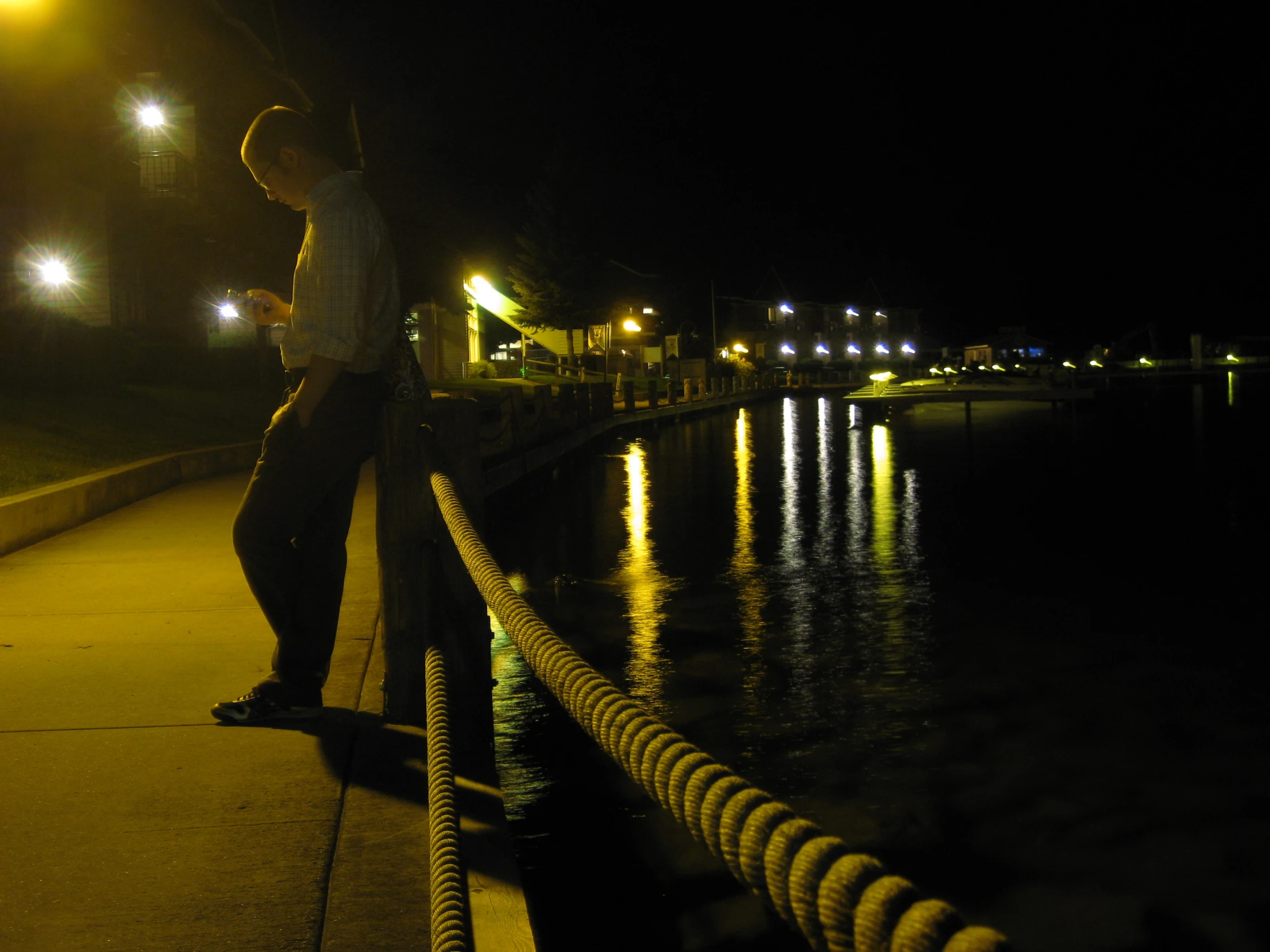 a person leaning against the dock at night