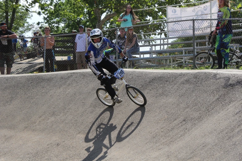 a man riding a bike through a cement park