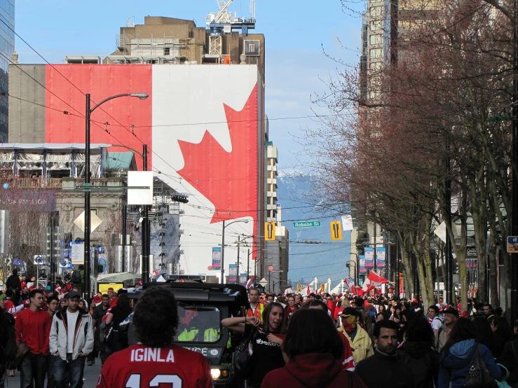 a group of people are on the street with a canadian flag