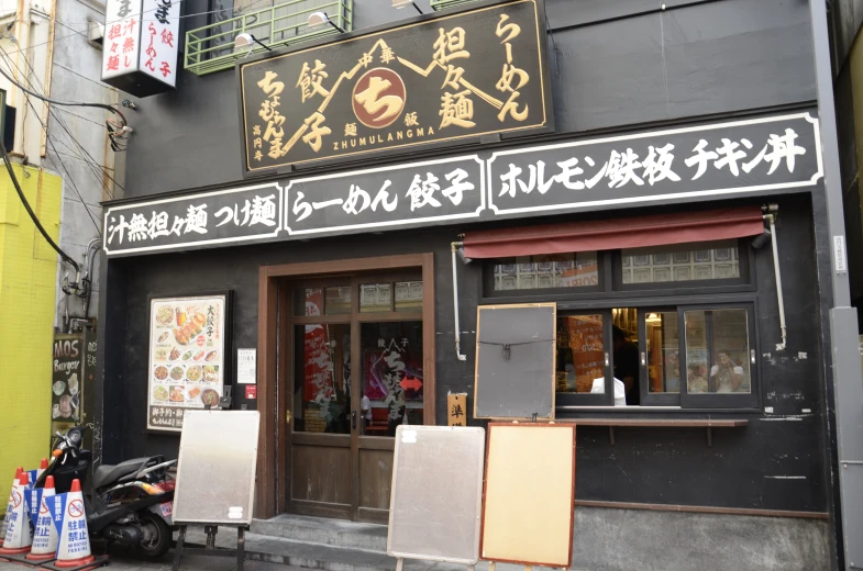 a store with asian writing on the window in an alley