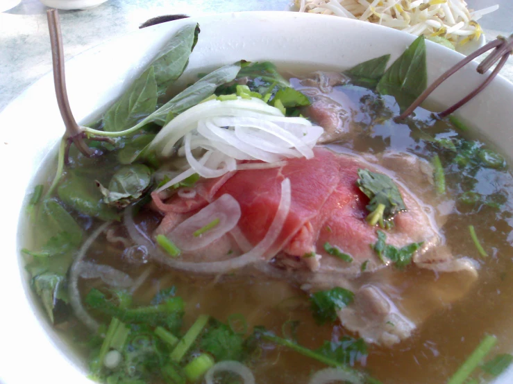 a bowl filled with meat and veggies sitting on top of a table