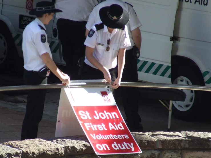 two police officers in uniforms stand behind a sign