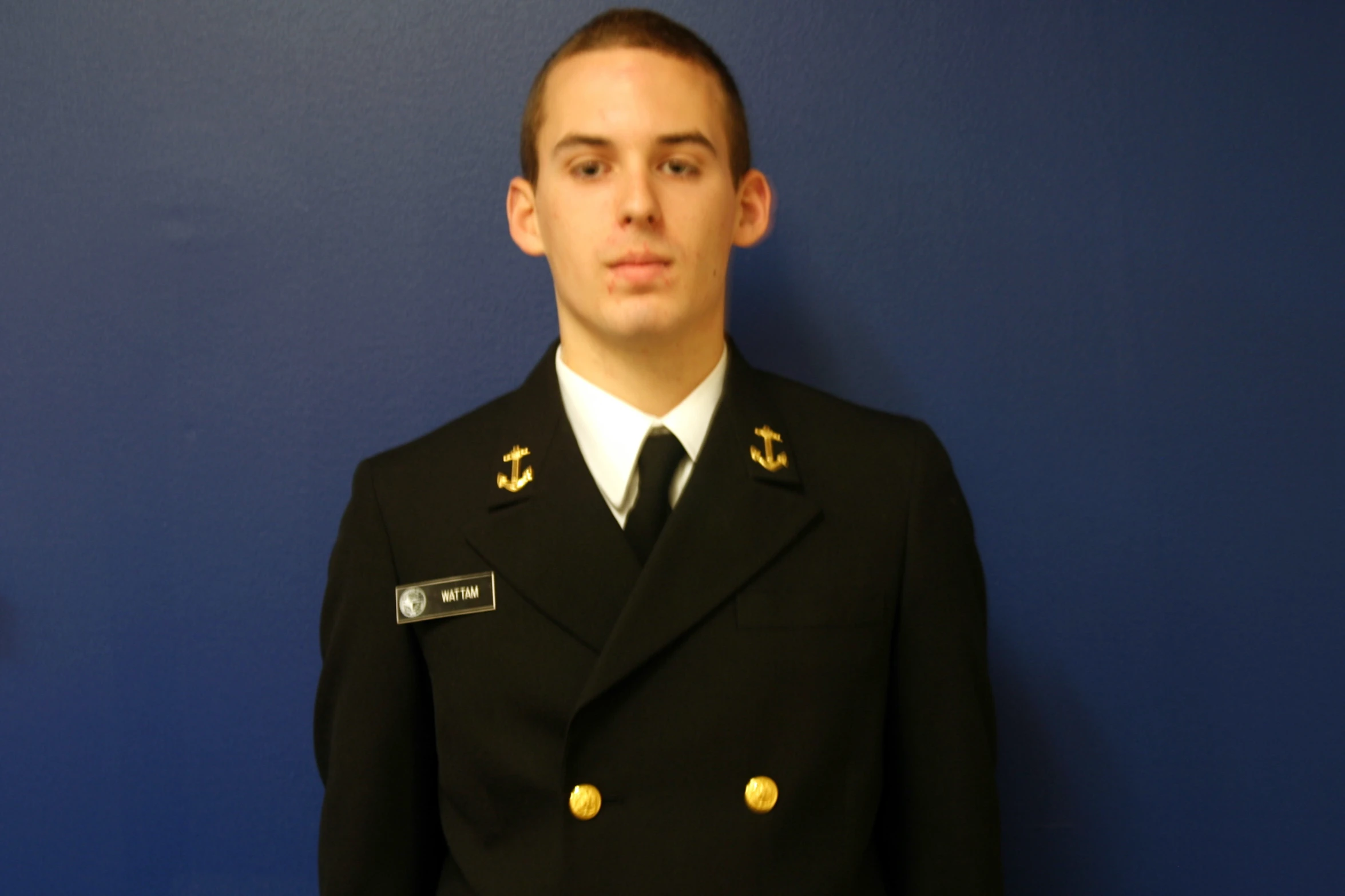 a young man in uniform poses for the camera