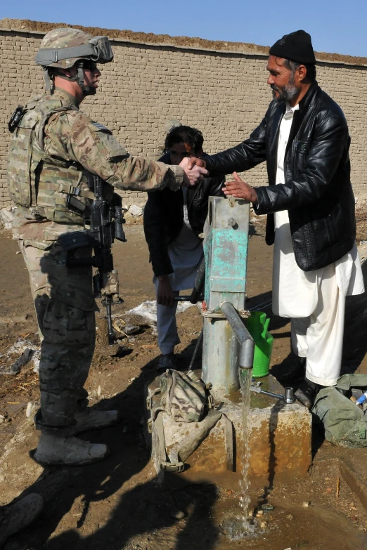 a soldier handing another person soing to shake