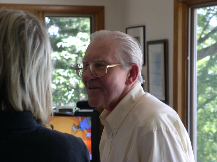 an older man is talking to an old lady